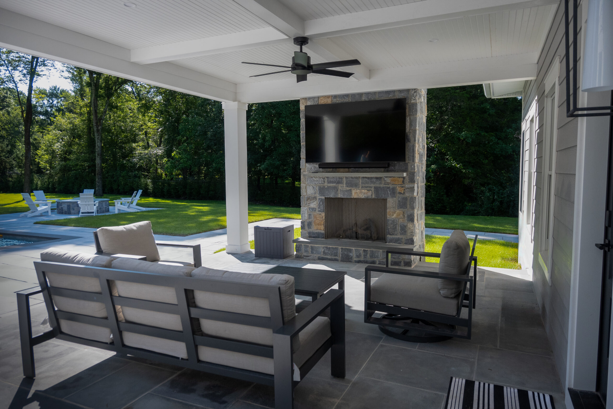 A backyard covered patio with a built in fireplace